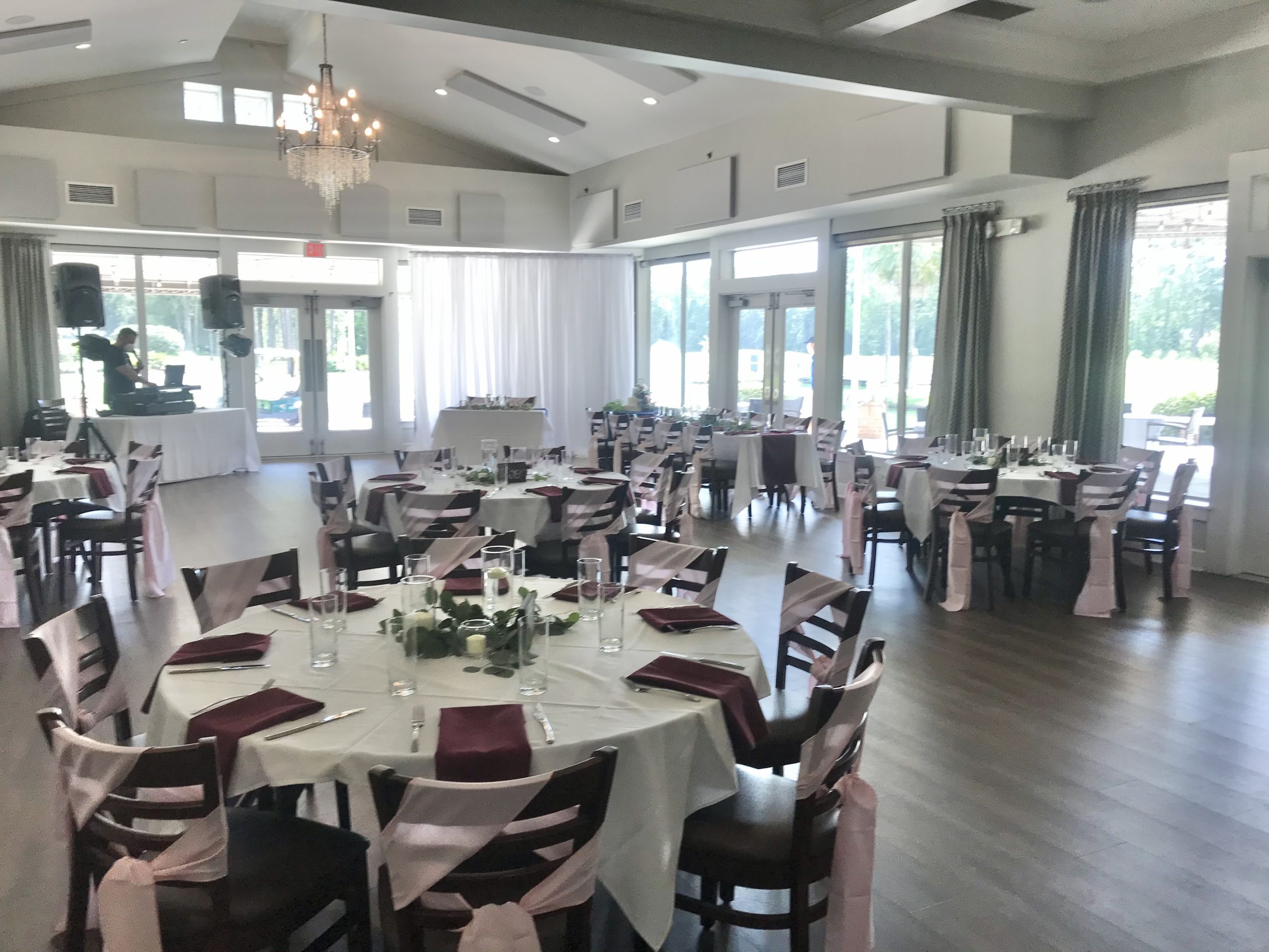 Venue space with round tables set for an event with table clothes and fancy table setting
