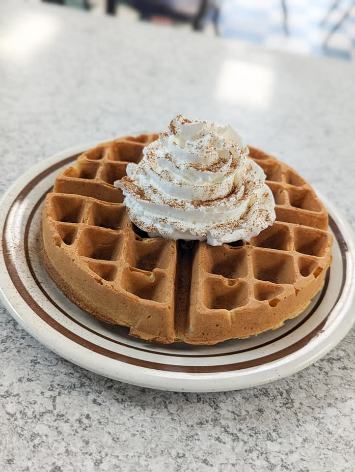 waffle plated with whipped cream on top