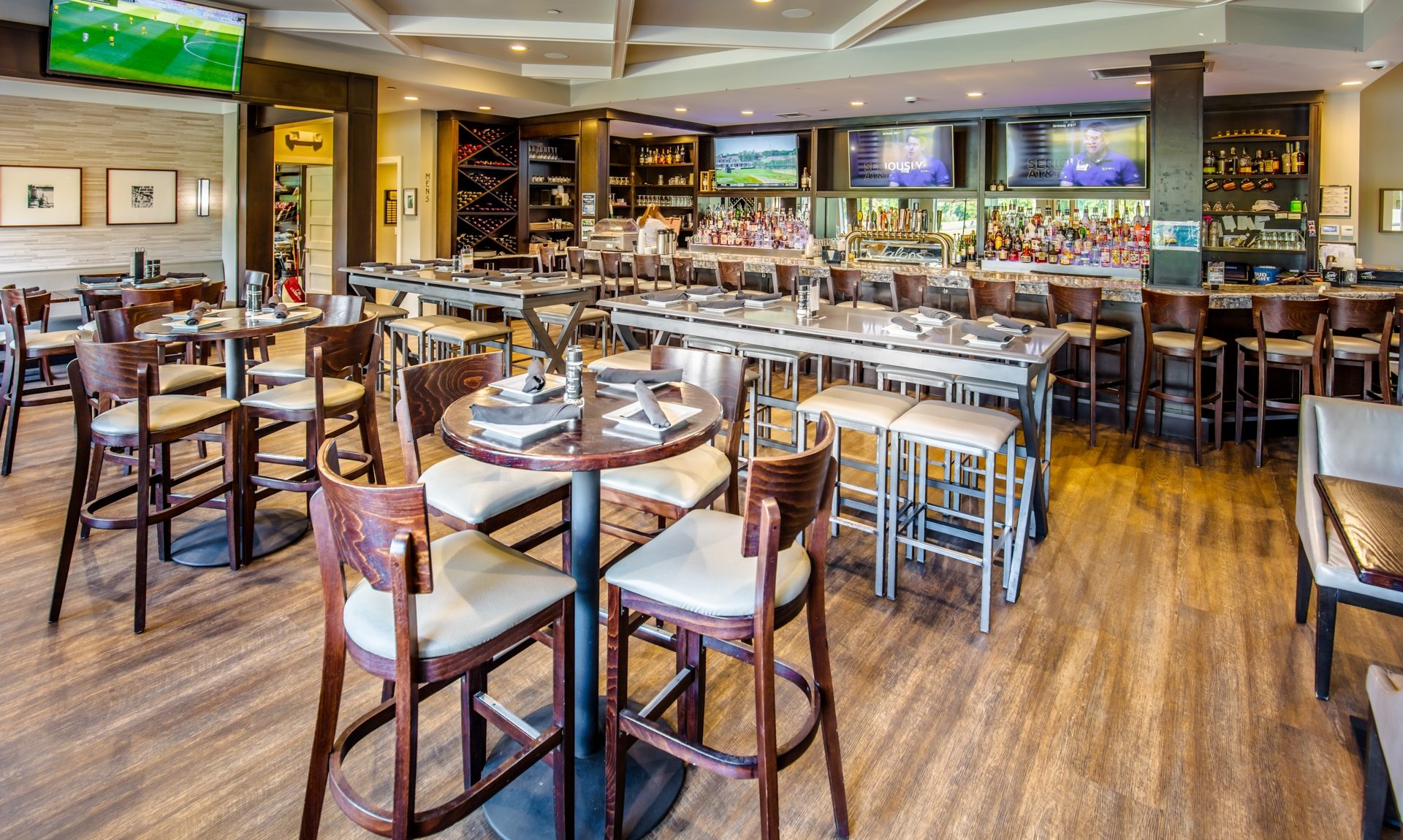 Inside of a sports bar featuring tall tables and seating and atmosphere
