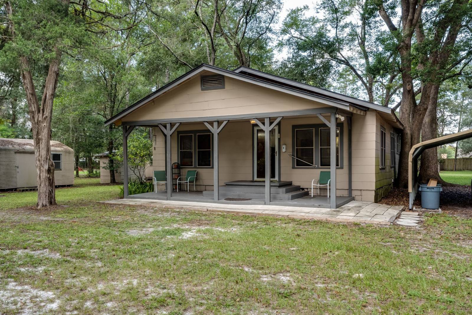 brown colored house with a front porch and large front yard