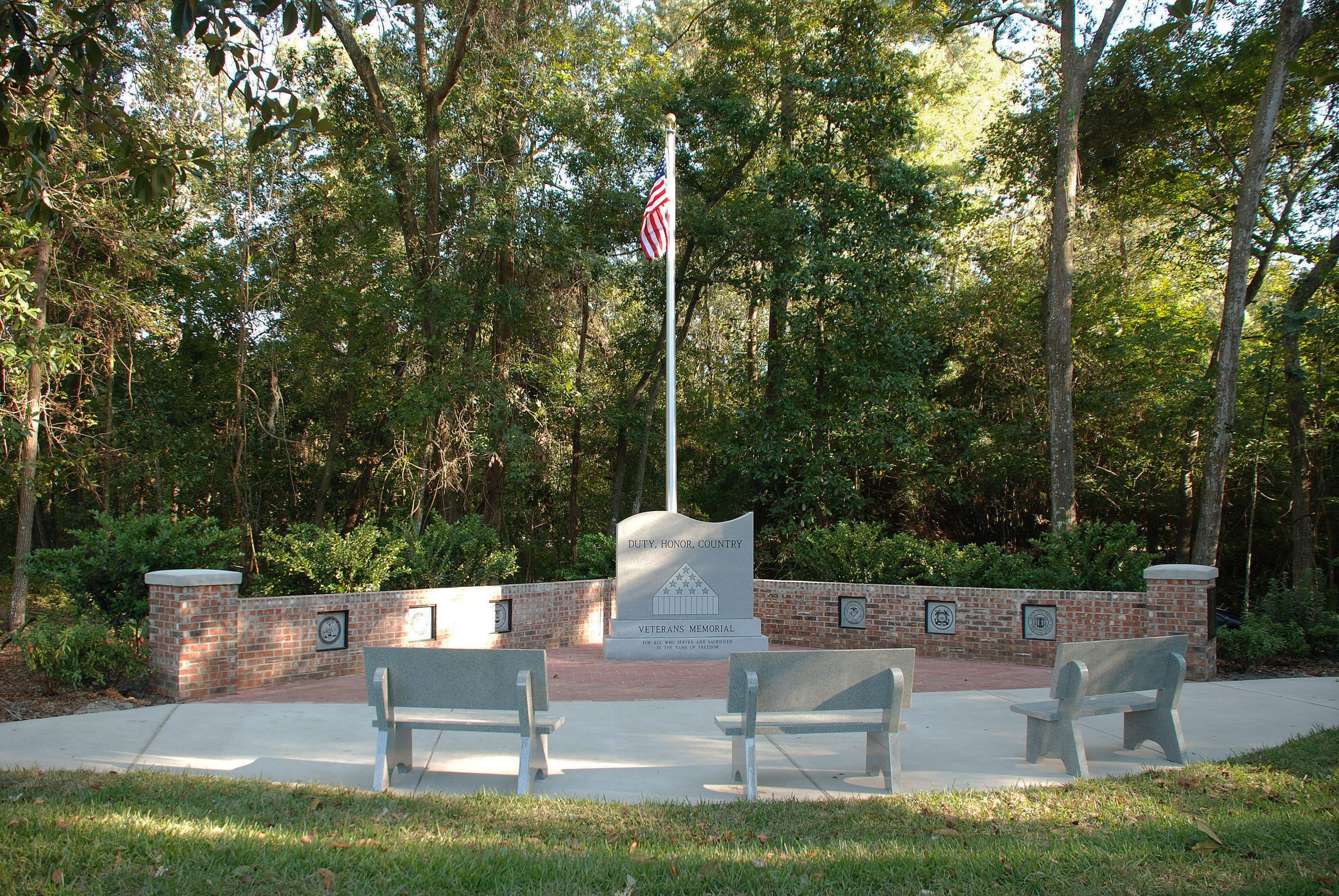 veteran memorial with american flag in a park with benches