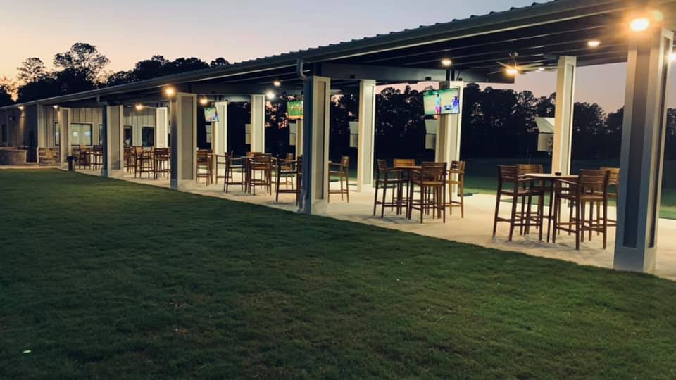 Outdoor golf experience with bays and high top tables