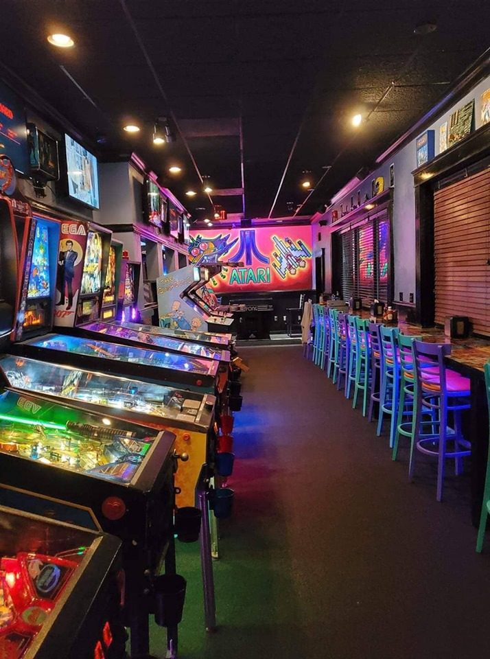 pinball machines lined up in an arcade