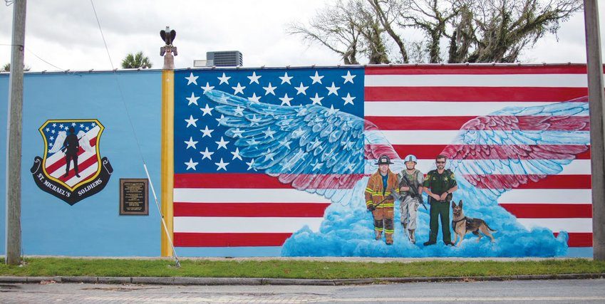 a flag mural on a building with local heroes