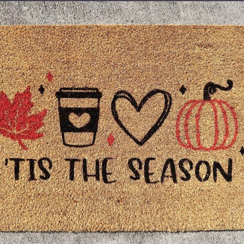Doormat with text that says 'Tis The Season and images of a red maple leaf, coffee, heart and pumpkin