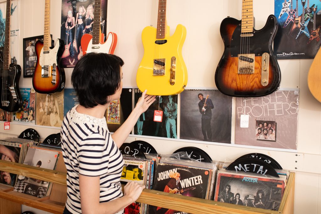 Woman looking at guitar at Guitar Station