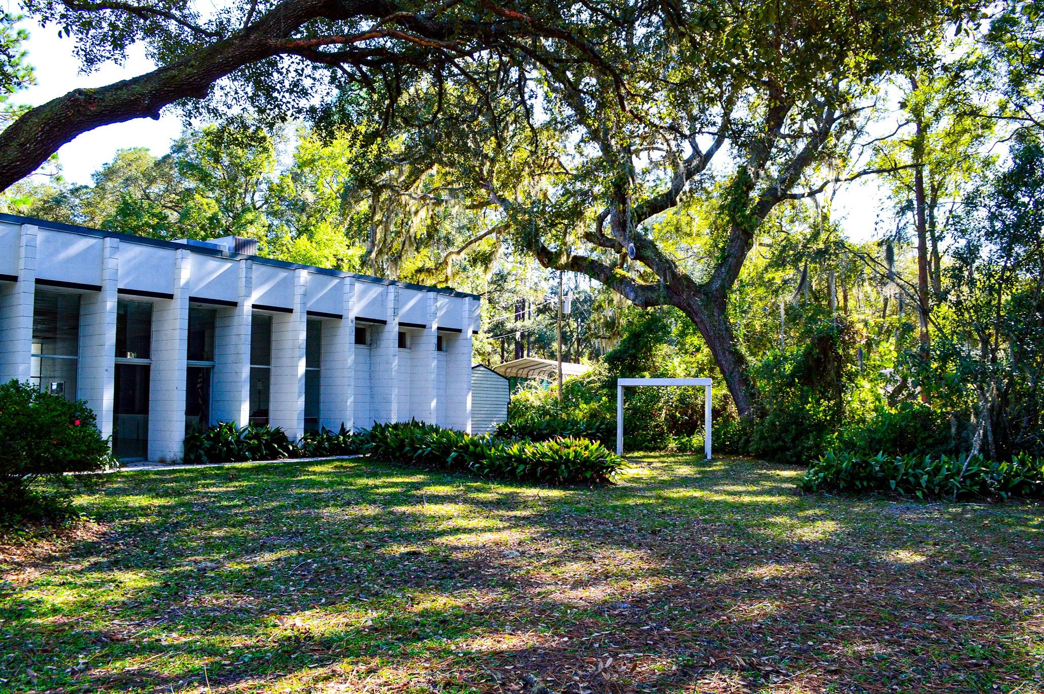 Outside view of the Keystone Heights Womans Club, white building with green yard and large trees