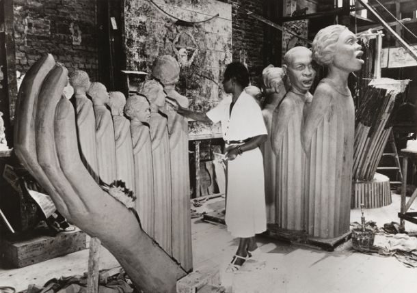 Black and white photo of a woman creating sculptures.