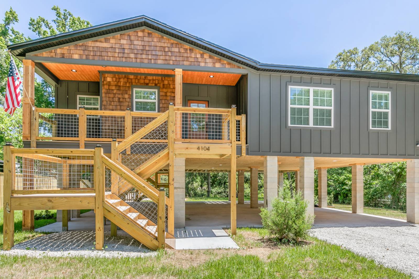 Two story house with green siding and wood staircase