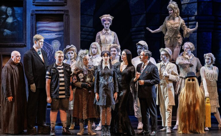 Addams Feature Photo Group of actors on stage playing the Addams Family.