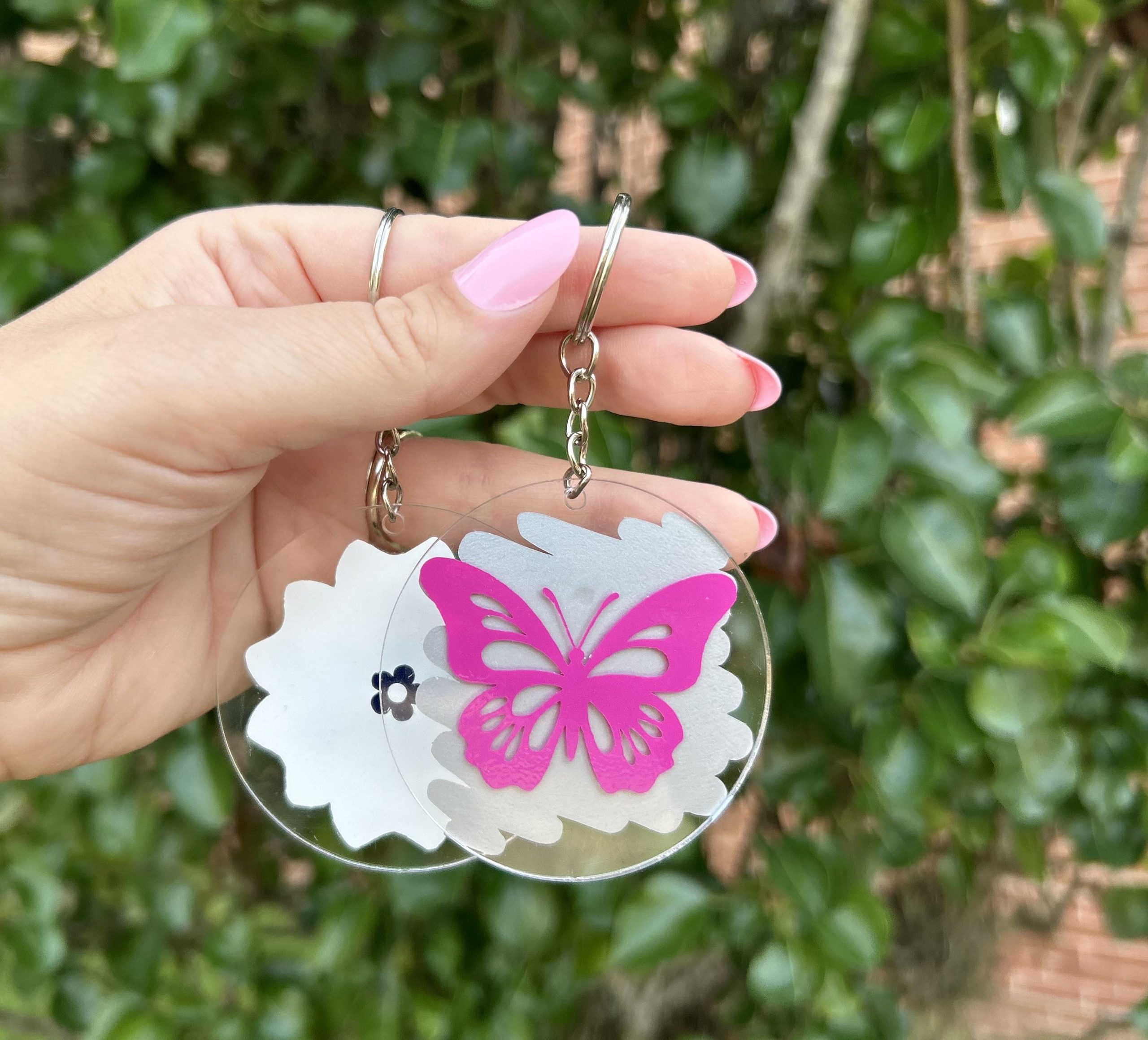 Keychain Feature Photo Photo of a hand holding two circle keychains, one with a pink butterfly.