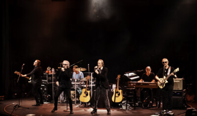 ThreeDogNight Feature Photo Bandmates performing on stage.